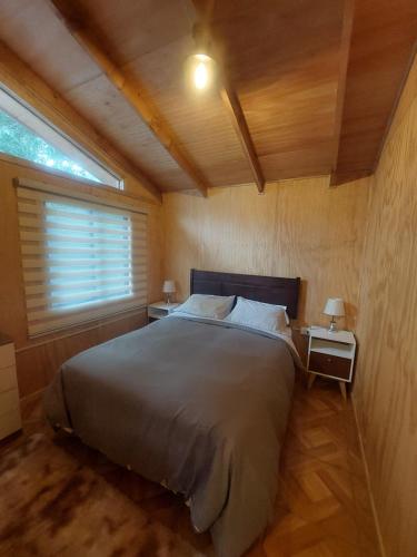 um quarto com uma cama grande e 2 mesas de cabeceira em La Posada em Neltume