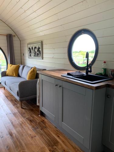 a kitchen with a sink and a couch in a room at Laurel Farm Glamping in Mark