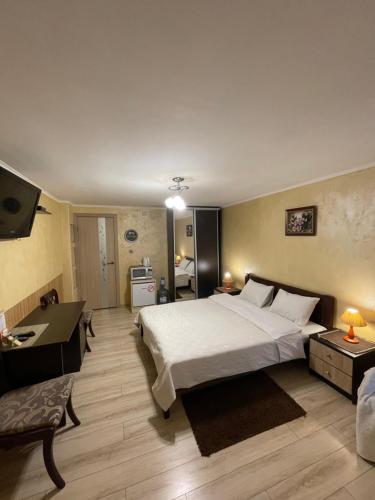 a large bedroom with a large bed and a desk at Guest House SunRise in Kamianets-Podilskyi