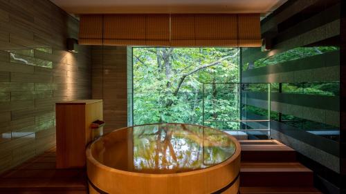 a wooden tub in a bathroom with a large window at Fufu Nikko in Nikko