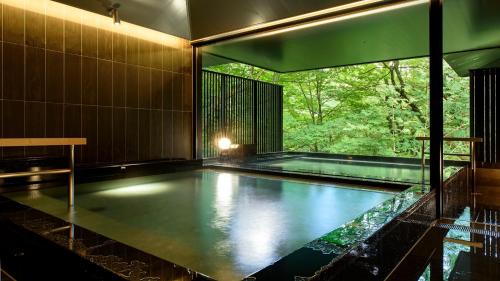 a swimming pool in a house with a large window at Fufu Nikko in Nikko