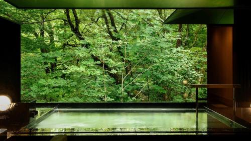 a large window in a room with a tree at Fufu Nikko in Nikko