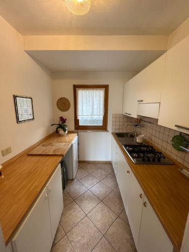 a kitchen with white cabinets and a counter top at DOLOMITI HOUSE 6 in Fiera di Primiero