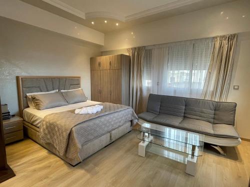 um quarto com uma cama e um sofá em STUDIO BORJ RAYHANE em Tânger