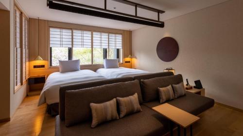 a hotel room with two beds and a couch at Fufu Kyoto in Kyoto