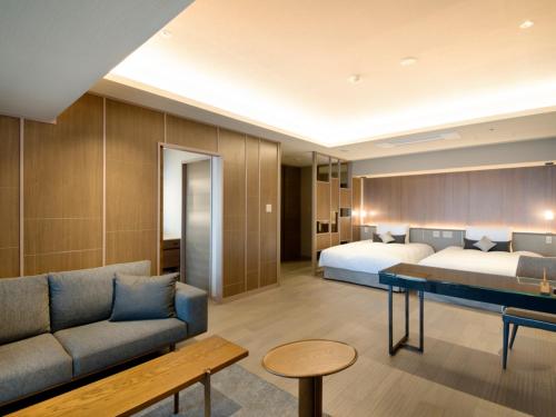 pokój hotelowy z 2 łóżkami i kanapą w obiekcie Atami Sekaie w mieście Atami