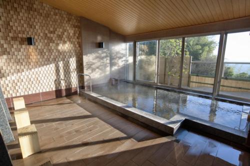 ein großer Pool in einem Gebäude mit einem großen Fenster in der Unterkunft Atami Sekaie in Atami