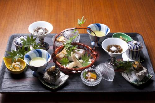 a tray of food on a table with plates of food at Atami Sekaie in Atami