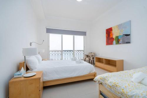 um quarto com 2 camas e uma janela em Stunning 2BD Sea View Apartment Private Beach Access em Ras al-Khaimah
