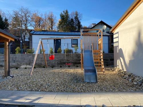 a playground with a slide in a yard at Vila Kosmonautka - Velké Losiny in Velké Losiny