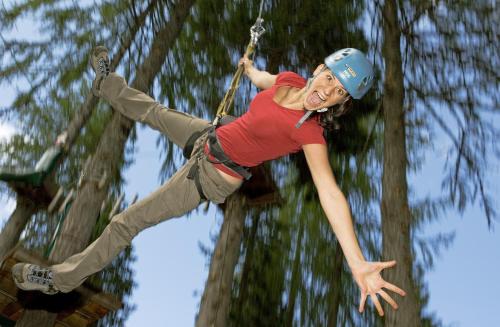 a woman is hanging on a rope swing at Aktiv & Sport Apartments Oberjörg in Rattendorf