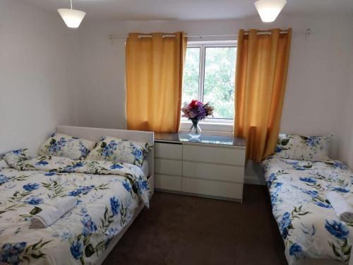 1 dormitorio con 2 camas, vestidor y ventana en Superb 2 bedroom flat, sleeps 6, en Croydon