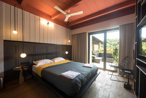 a bedroom with a bed with a ceiling fan at East India House in Gorai