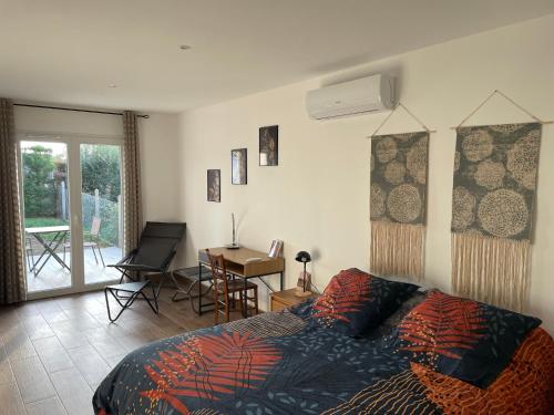 a bedroom with a bed and a desk and a window at Au Clos Decoeur in Salaise-sur-Sanne
