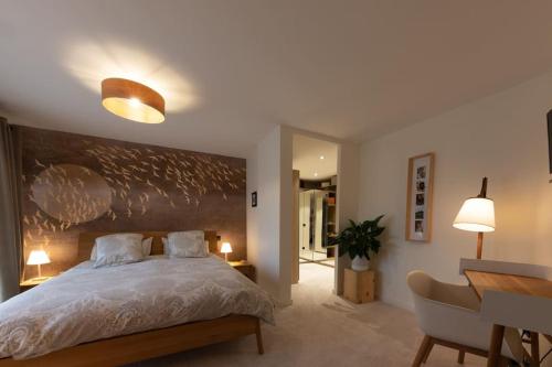 - une chambre avec un grand lit, une table et un bureau dans l'établissement Villa luxe, au calme avec piscine à 5min du lac, à Annecy