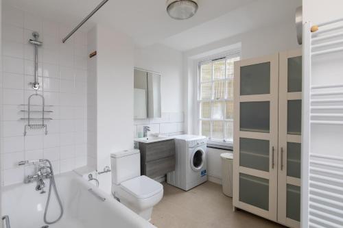 a bathroom with a toilet sink and a washing machine at Flat near Lord's Cricket Ground in London