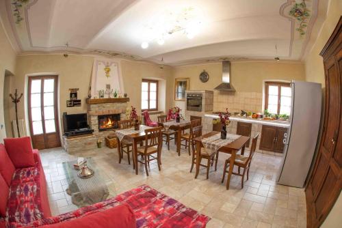 a kitchen and living room with tables and a fireplace at Agriturismo Rihane in Sinio