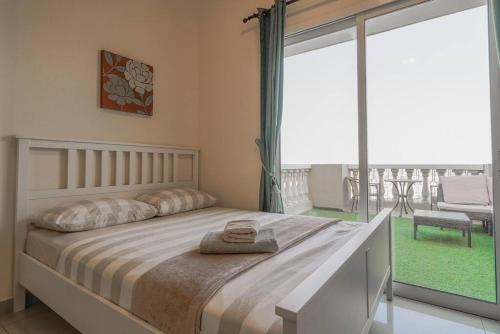 a bedroom with a large bed and a large window at Relaxing, Swimming and Golfing in Al Hamra Village in Ras al Khaimah