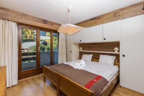 - une chambre avec un grand lit et une grande fenêtre dans l'établissement Apartment La Foret, à Riddes