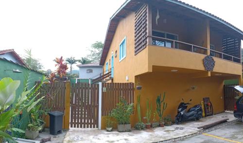 una casa con una motocicleta estacionada frente a ella en Camburi suites en Camburi