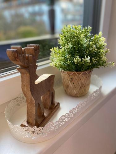 a couple of wooden figurines on a window sill with a plant at Haus Kulala in Kaprun