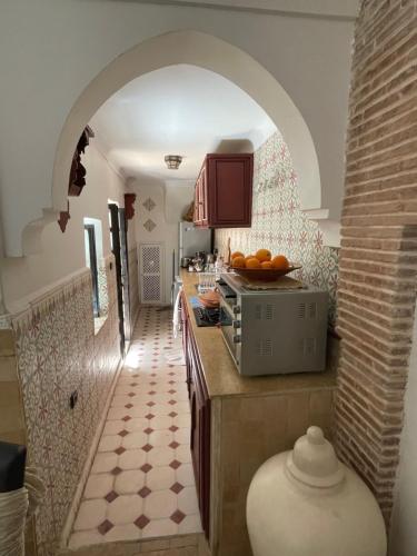 a kitchen with an archway and a counter with oranges on it at Riad Lalla Nora in Marrakech