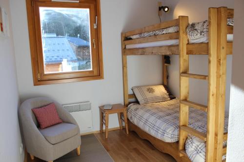 a bedroom with a bunk bed and a chair and a window at Lovely spacious apartment (+garage) in La Plagne in Plagne 1800