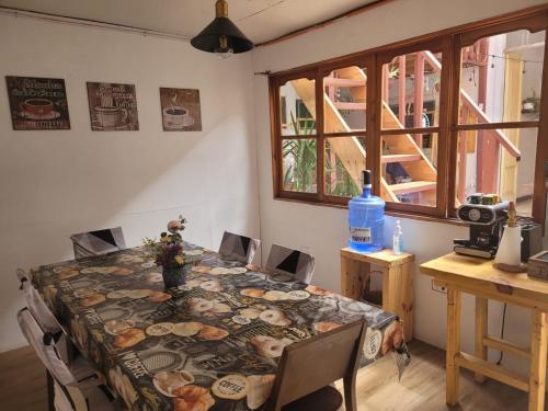 comedor con mesa, sillas y ventana en Hospedaje en mi casa, en Iquique