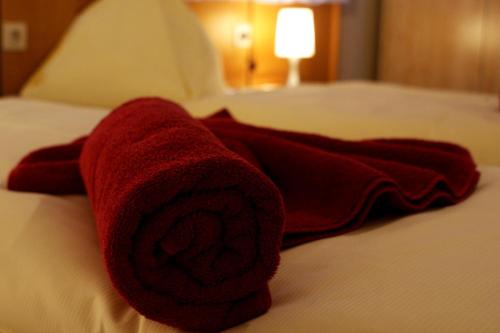 a red towel sitting on top of a bed at Gästehaus Elisabeth in Radstadt