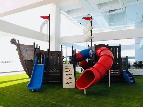 une aire de jeux avec un toboggan rouge et bleu dans l'établissement The Wave Residence Melaka - A, à Malacca
