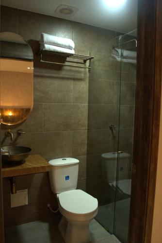 a bathroom with a toilet and a glass shower at AITABU HOTEL CAMPESTRE in Villavicencio