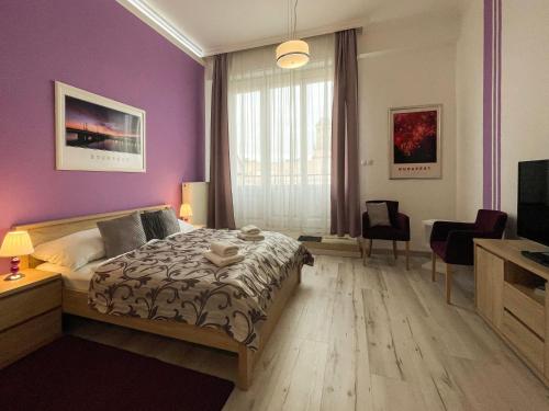 a bedroom with a bed and a purple wall at ABT Apartments Karoly in Budapest