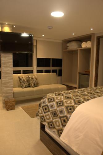 a living room with a bed and a couch at AITABU HOTEL CAMPESTRE in Villavicencio