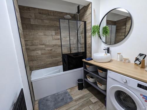 een badkamer met een bad, een wastafel en een wasmachine bij Appt cosy en cœur de ville proche Lille - 15 min in Tourcoing