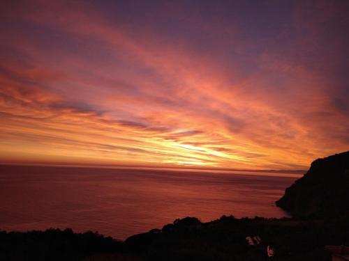 a sunset over the ocean with the sun setting at Perla del Levante Hostel in Framura