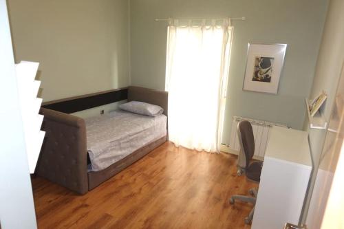 a small bedroom with a bed and a wooden floor at Antolín Yellow Door in Ponferrada