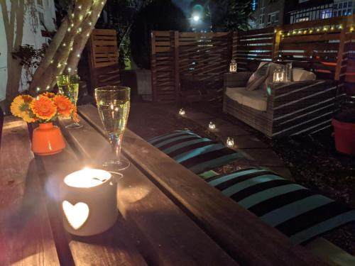 a wooden table with a candle and flowers on it at *Unique Brighton Apartment & Garden, near Beach* in Brighton & Hove