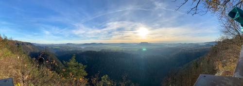 a view of a valley with the sun in the sky at Am Fuße zur Napoleonschanze in Hohnstein