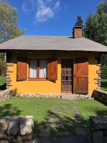 a yellow house with wooden doors and windows at Agradable casa con chimenea interior in Camprodon