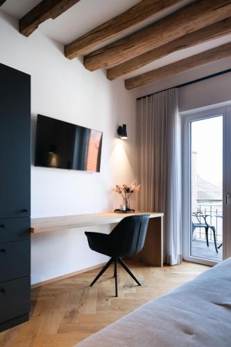 a bedroom with a desk with a television and a chair at TORhaus Appartments Sendenhorst in Sendenhorst