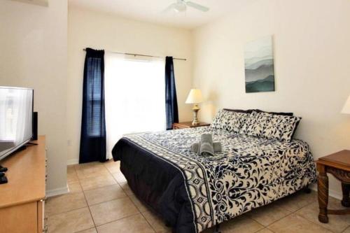 a bedroom with a bed and a television at Family Friendly 3BR near Disney in Kissimmee