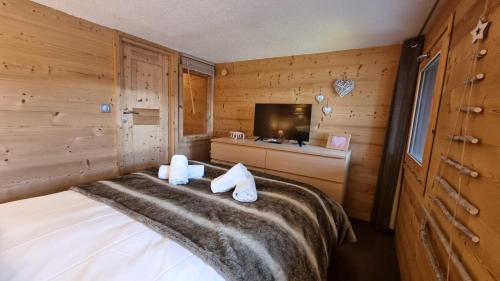 a bedroom with a bed and a tv in a room at So cosy Val Thorens in Val Thorens