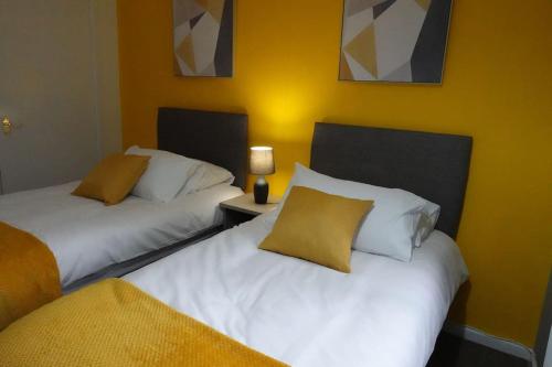 two beds sitting next to each other in a room at Stylish 3 Bedroom House Near NEC, City Centre in Birmingham