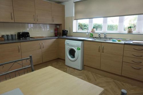 a kitchen with a washing machine and a sink at Stylish 3 Bedroom House Near NEC, City Centre in Birmingham