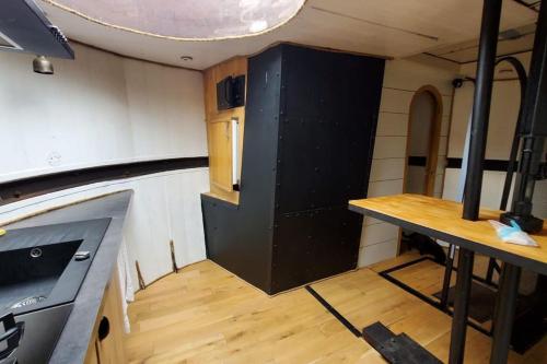 a kitchen with a black cabinet in a room at Appartement dans Péniche atypique et idyllique à Confluence in Lyon