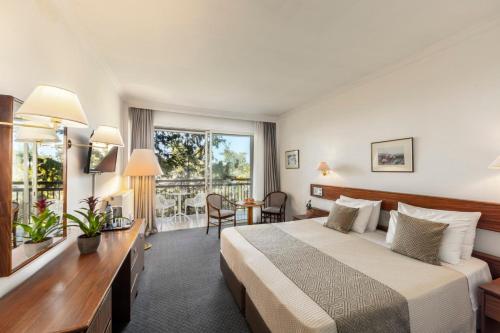een hotelkamer met een bed en een groot raam bij Forest Park Hotel in Platres