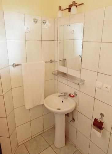 a white bathroom with a sink and a mirror at Pallotti Hotel in Kigali