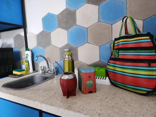 eine Küchentheke mit Spüle und einem Rucksack in der Unterkunft CASA MARGARITA 3Piso Monoambiente in San Salvador de Jujuy