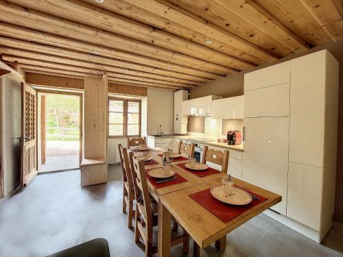une salle à manger avec une table en bois et une cuisine dans l'établissement CHEZ HENRI Appartement 4 a 6 personnes proche remontees mecaniques, à Saint-Jean-dʼAulps