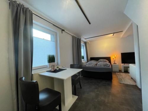 Zimmer mit einem Schreibtisch, einem Bett und einem Fenster in der Unterkunft Gleis 12 , kontaktloser 24-7-Check In, barrierefrei ,Smart TV, W-LAN, Parkplatz kostenlos in Bückeburg